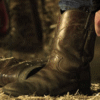 cowboy putting on cowboy boots